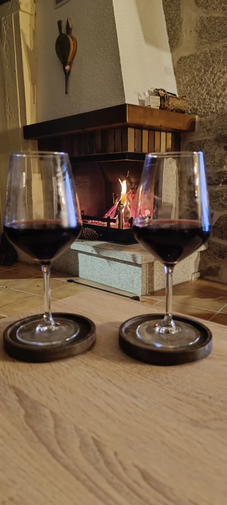 Copas de vino con chimena encendida al fondo